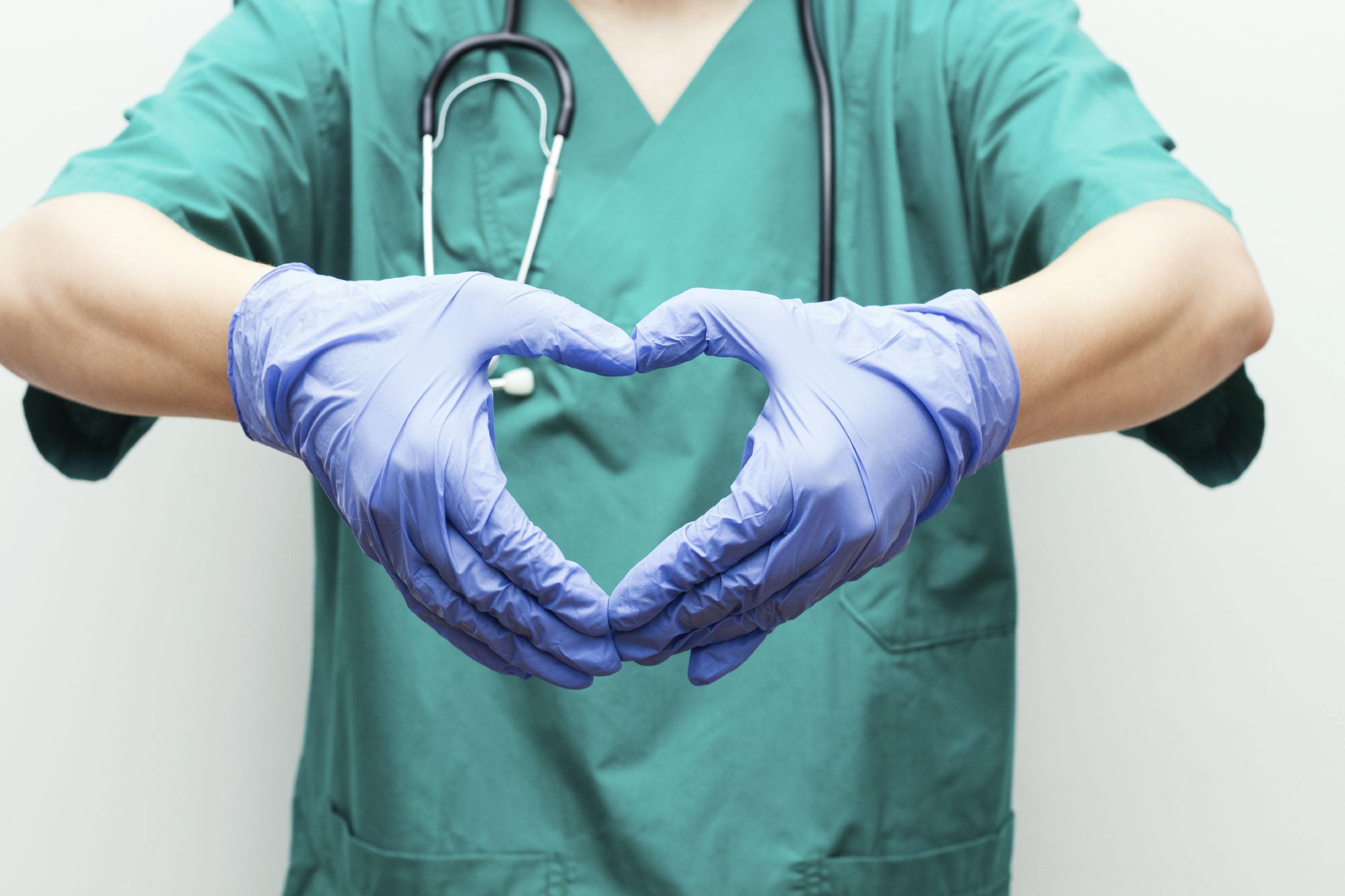 Krankenhausmitarbeiterin formt Herz mit Händen